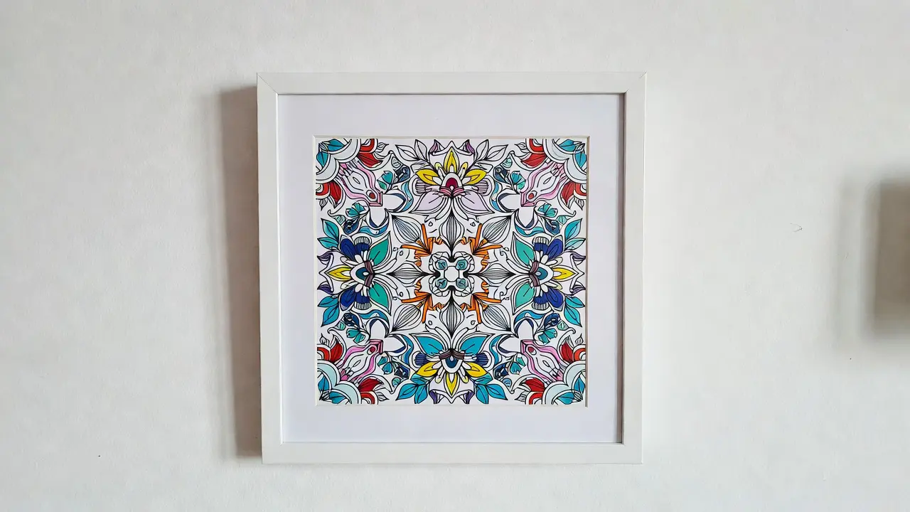 framed finished coloring page displayed on a minimalist white wall as home decor. DIY printable coloring page crafts